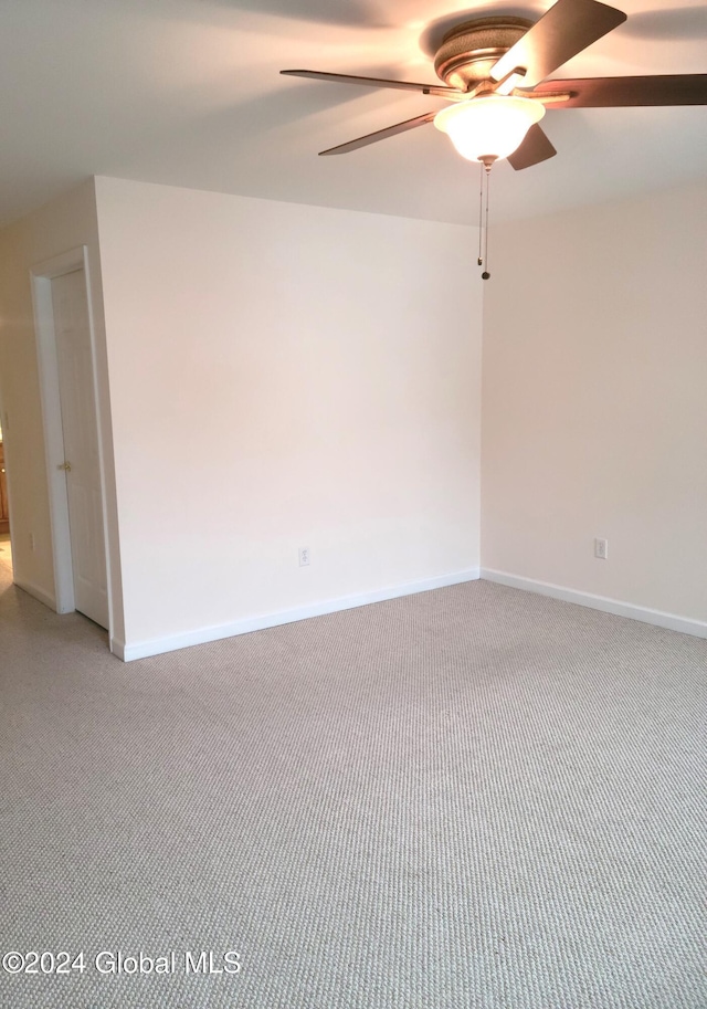 carpeted spare room with ceiling fan