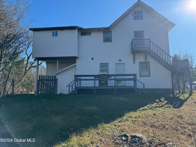 rear view of property featuring a yard and a wooden deck