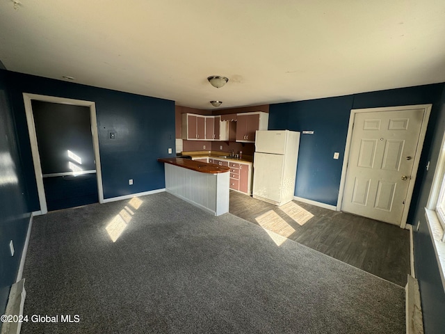 kitchen featuring dark hardwood / wood-style flooring, white fridge, and sink