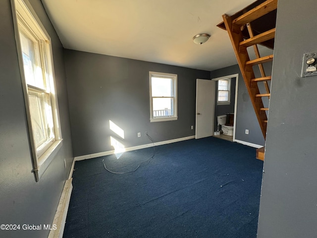 interior space featuring baseboard heating and dark carpet