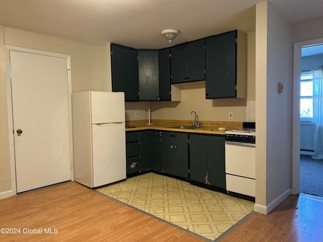 kitchen with light wood-type flooring, range, white refrigerator, and a baseboard heating unit