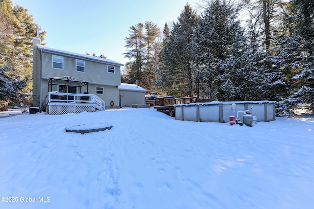 yard layered in snow with a gazebo and a swimming pool side deck