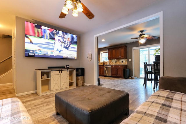 living room featuring ceiling fan and light wood-type flooring