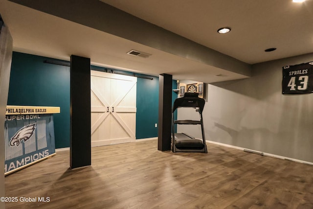 workout area featuring hardwood / wood-style floors and a barn door