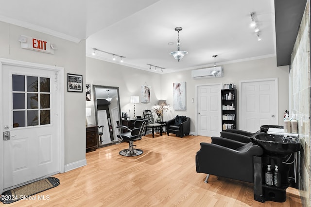 living room with hardwood / wood-style floors, ornamental molding, rail lighting, and a wall unit AC