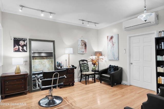 living area with a wall mounted air conditioner, hardwood / wood-style floors, rail lighting, and ornamental molding