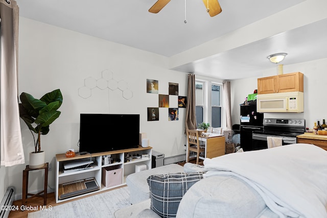 bedroom featuring hardwood / wood-style flooring, ceiling fan, black refrigerator, and a baseboard radiator