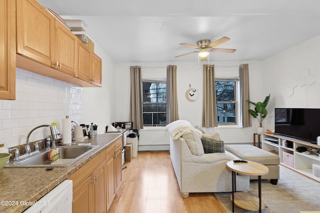 interior space featuring light brown cabinets, light wood-type flooring, a baseboard heating unit, and sink