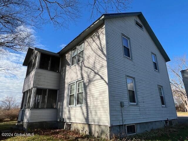 view of property exterior with a sunroom