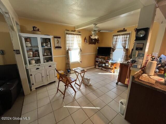 interior space with ceiling fan and crown molding