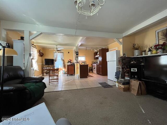 tiled living room with beamed ceiling and ceiling fan