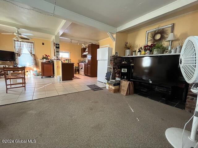 tiled living room featuring beamed ceiling and ceiling fan