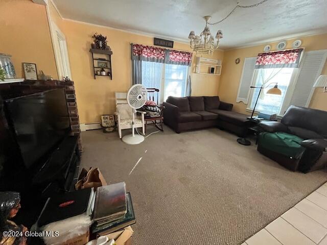 living room featuring a baseboard heating unit, crown molding, and an inviting chandelier