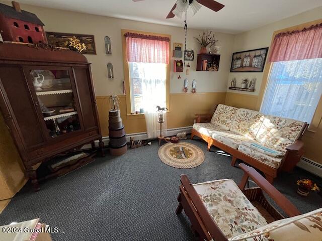 living area featuring carpet and ceiling fan