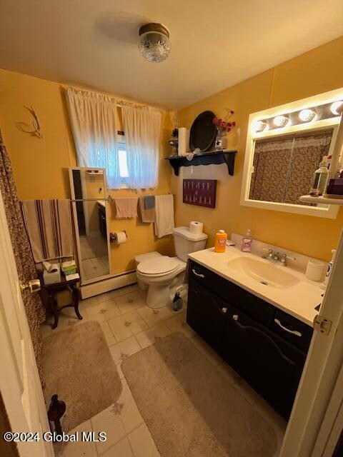 bathroom with tile patterned flooring, vanity, toilet, and a baseboard radiator