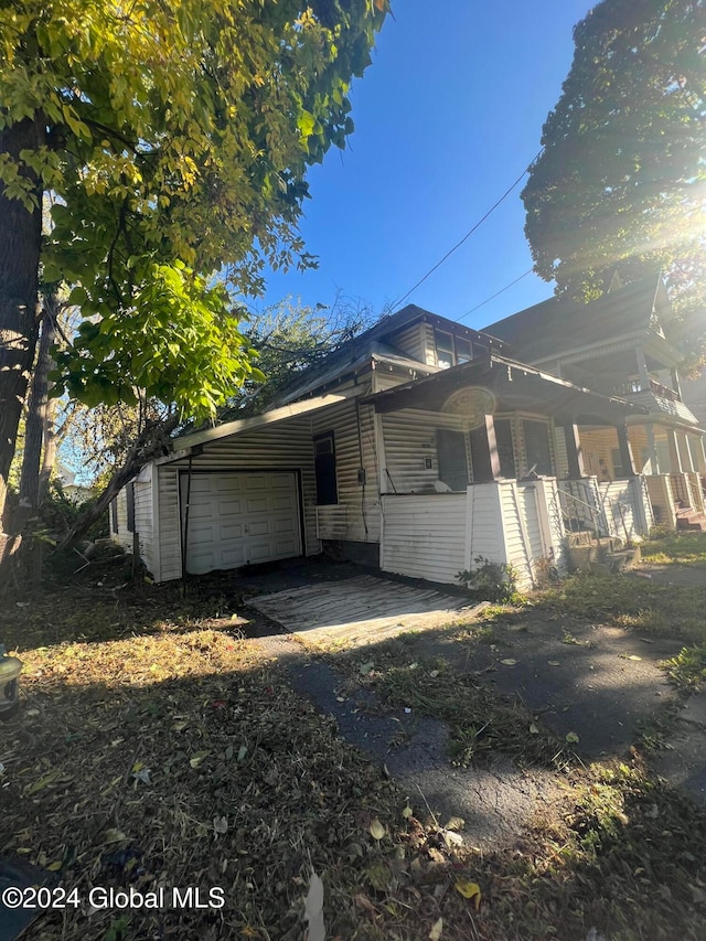 view of home's exterior with a porch and a garage