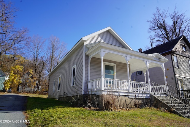 bungalow-style house with covered porch and a front lawn