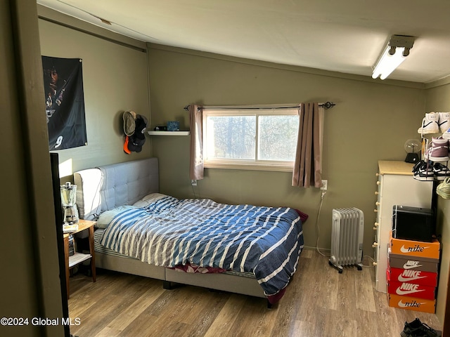 bedroom featuring hardwood / wood-style floors and radiator