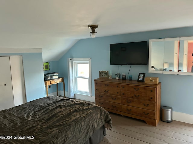 bedroom with lofted ceiling and light wood-type flooring