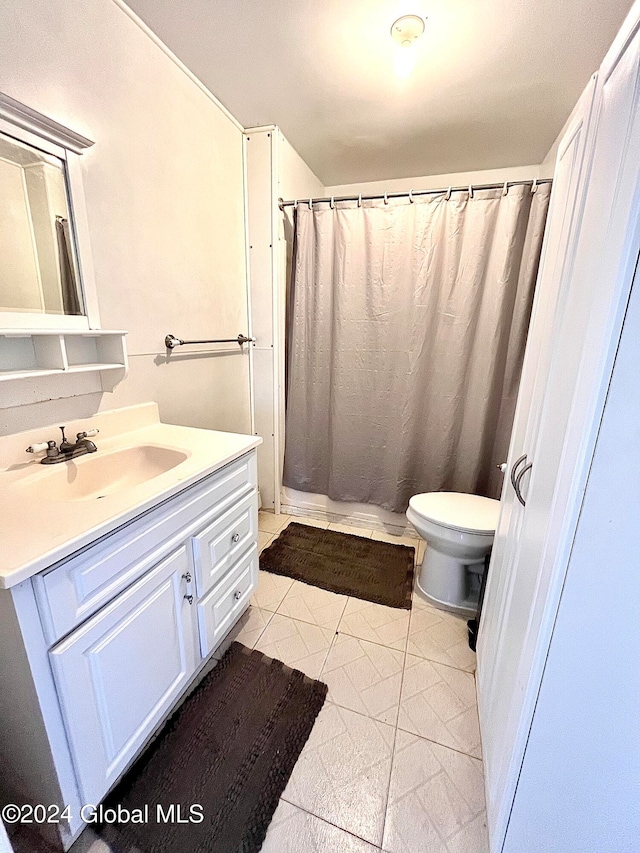 bathroom featuring tile patterned flooring, vanity, and toilet