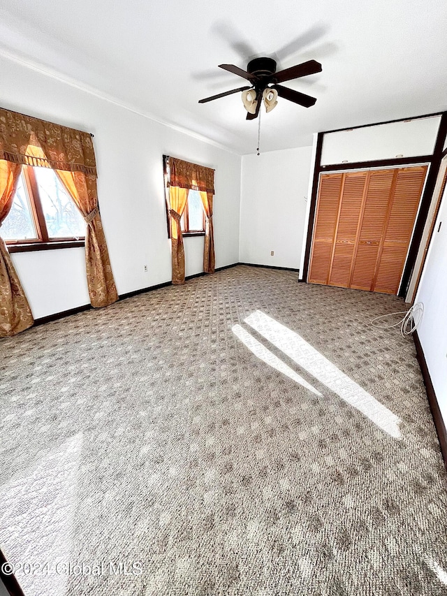 unfurnished bedroom with ceiling fan, carpet floors, and a closet