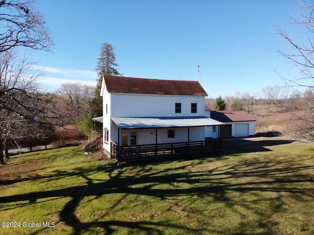 rear view of property with a garage and a lawn