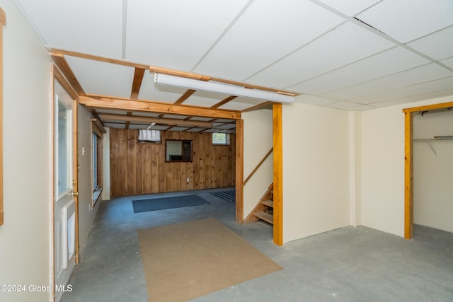 basement featuring wooden walls