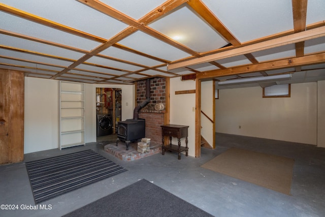 basement featuring washer / clothes dryer and a wood stove