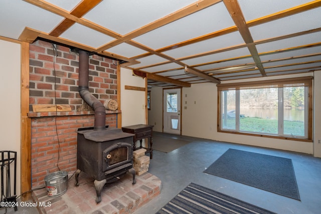 living room featuring concrete flooring and a wood stove