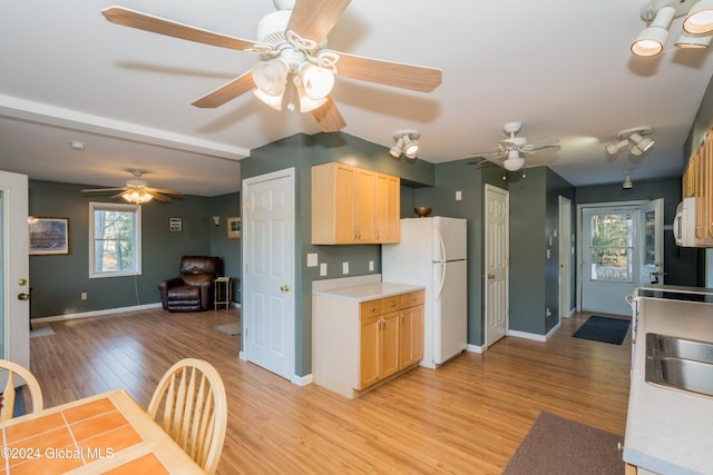 kitchen featuring sink, light brown cabinets, white appliances, and light hardwood / wood-style floors