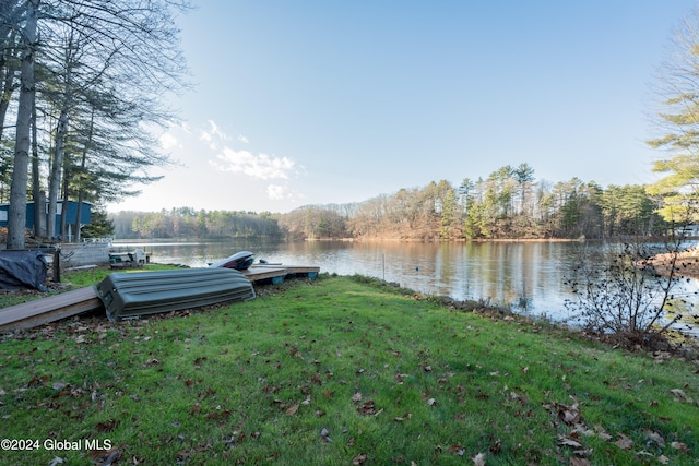 view of dock with a water view and a yard