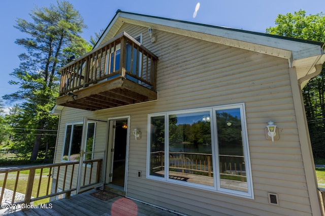 back of property featuring a wooden deck and a balcony