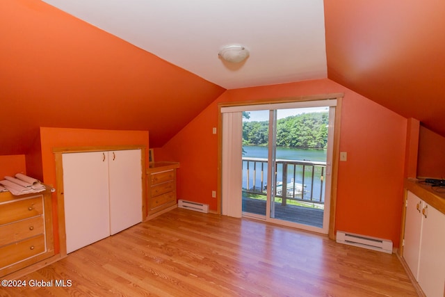 bonus room with vaulted ceiling, a water view, baseboard heating, and light hardwood / wood-style flooring