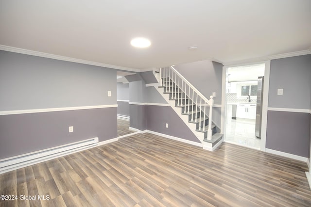 spare room with hardwood / wood-style flooring, ornamental molding, and a baseboard radiator