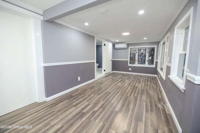 interior space featuring a wall mounted air conditioner, ornamental molding, and dark wood-type flooring