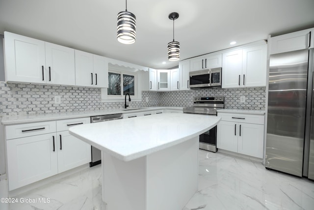 kitchen featuring pendant lighting, a center island, white cabinets, tasteful backsplash, and stainless steel appliances