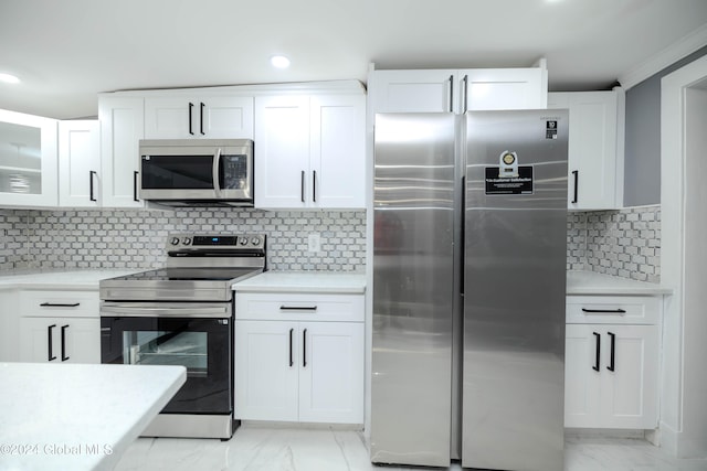 kitchen featuring white cabinets, decorative backsplash, and stainless steel appliances