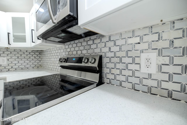 kitchen featuring backsplash, white cabinetry, and stainless steel appliances