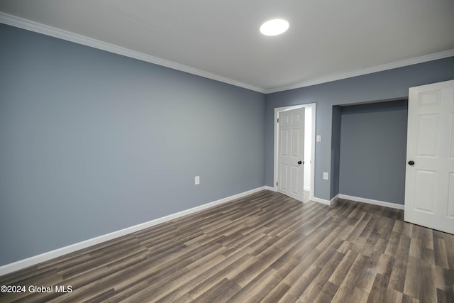 unfurnished bedroom featuring crown molding, dark wood-type flooring, and a closet