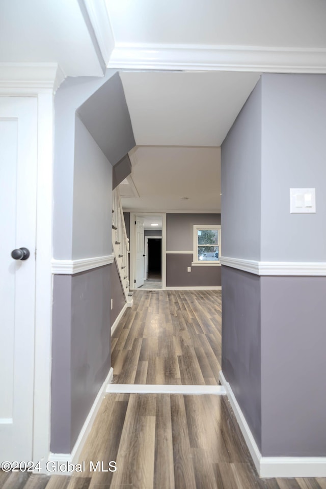 corridor with ornamental molding and dark wood-type flooring