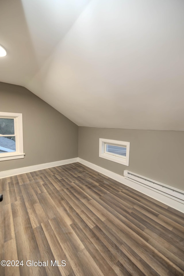 bonus room with dark wood-type flooring, vaulted ceiling, and a baseboard heating unit