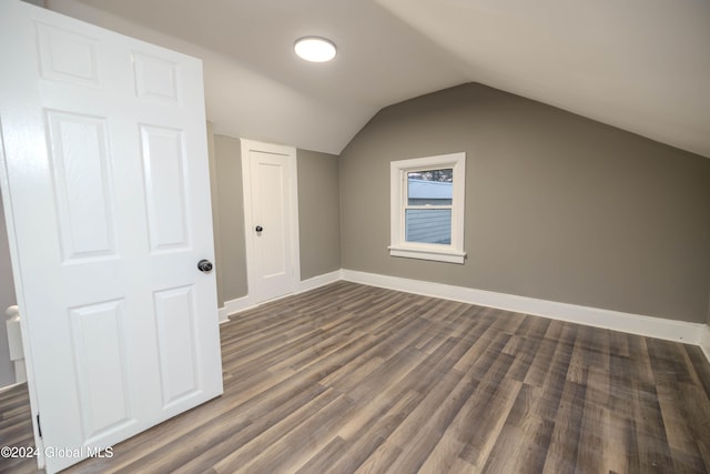 bonus room with dark hardwood / wood-style floors and vaulted ceiling