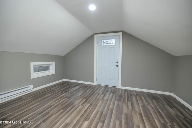 additional living space with a baseboard heating unit, lofted ceiling, a wealth of natural light, and dark wood-type flooring