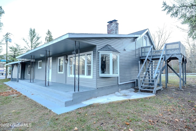 rear view of house featuring covered porch