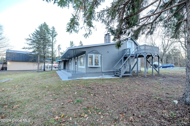 rear view of house featuring a yard and a patio