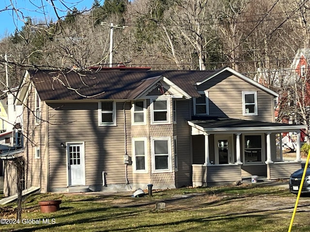 view of front of house with covered porch and a front lawn