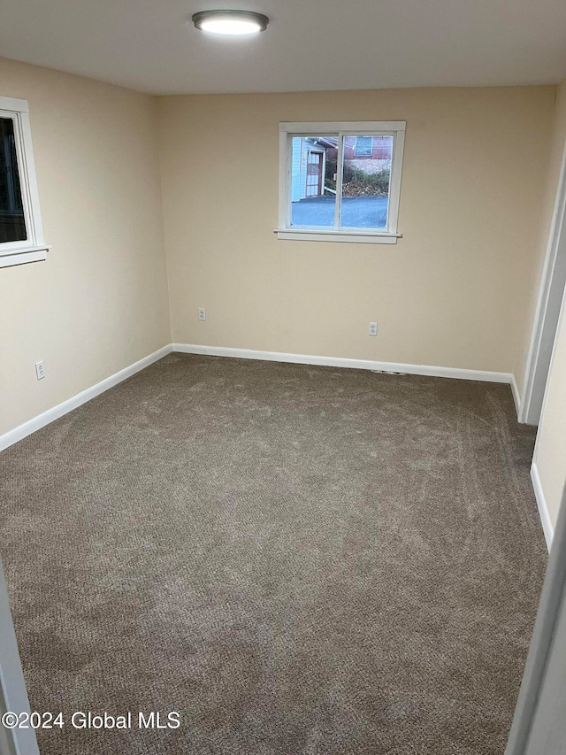 spare room with dark colored carpet