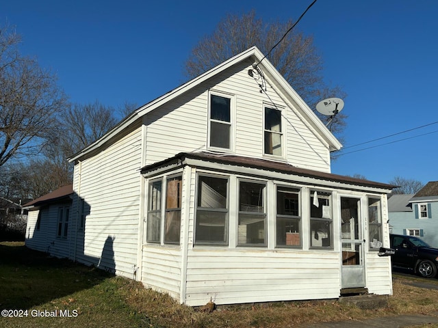 view of property exterior with a sunroom