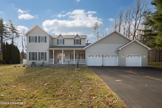 view of front of property with a porch, a garage, and a front lawn