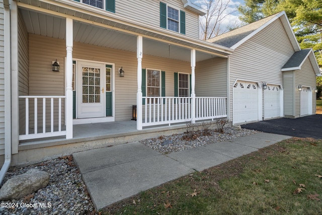 doorway to property featuring a porch and a garage